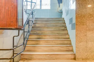 a staircase in a school with wooden floors and blue tiles at Hotel O Kota Lodge in Coimbatore