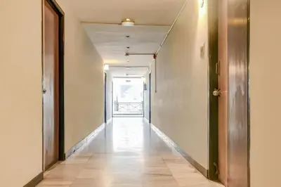 an empty hallway with a hallway and a door at Hotel O Kota Lodge in Coimbatore