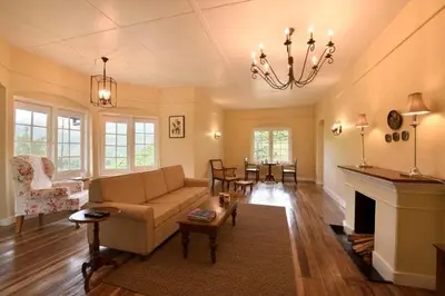 a living room with a couch and a fireplace at Ama Stays and Trails Tea Estate Bungalows , Munnar in Munnar
