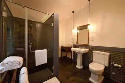 a bathroom with a toilet and a sink and a shower at Ama Stays and Trails Tea Estate Bungalows , Munnar in Munnar