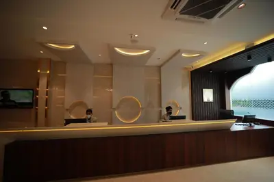 two people sitting at a reception desk in a lobby at Nesma Palace in Kannur