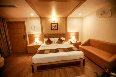 a hotel room with a bed and a couch at Nesma Palace in Kannur