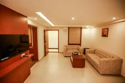 a living room with two couches and a flat screen tv at Nesma Palace in Kannur