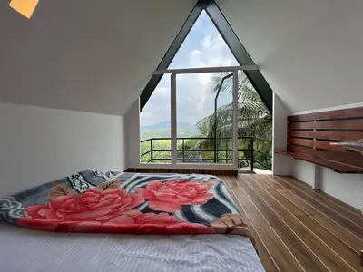 a bedroom with a bed with a large window at Casita Greens in Kondotti