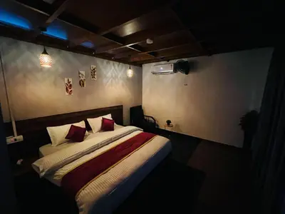 a bedroom with a bed with red pillows at Casita Greens in Kondotti