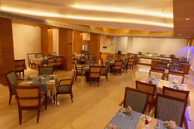 a dining room with tables and chairs in a restaurant at Diana Heights Luxury Hotel in Nedumbassery