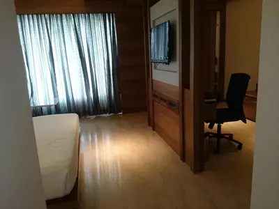 a hotel room with a bed and a desk and a television at Diana Heights Luxury Hotel in Nedumbassery