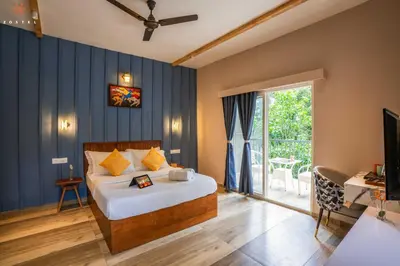 a bedroom with a bed and a desk and a television at Zostel Coorg, Madikeri in Madikeri