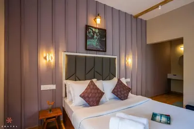 a bedroom with a large bed with white sheets and pillows at Zostel Coorg, Madikeri in Madikeri