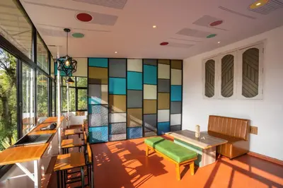 a dining room with a stained glass wall at Zostel Coorg, Madikeri in Madikeri