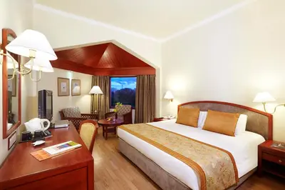 a hotel room with a large bed and a desk at The Gateway Hotel Beach Road, Calicut in Kozhikode