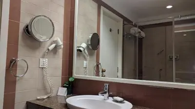 a bathroom with a sink and a mirror and a phone at The Gateway Hotel Beach Road, Calicut in Kozhikode