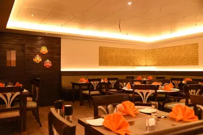 a dining room with tables and chairs in a restaurant at The Gateway Hotel Beach Road, Calicut in Kozhikode