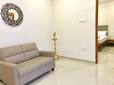a living room with a couch and a mirror at MALLI resort in Dhārāpuram