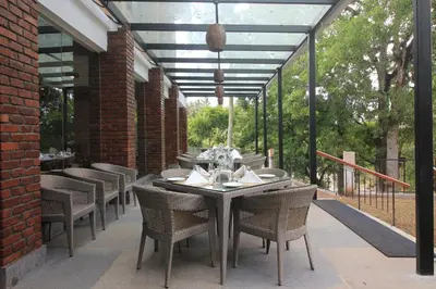 a patio with a table and chairs on a patio at Regenta Jungle Resort Kabini Springs in Begūr