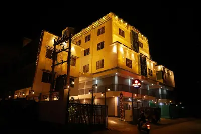 a large yellow building with lights on it at night at Zubis Inn Hotel in Kalpetta