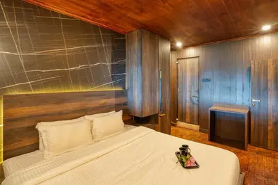 a bedroom with a large bed with a white bedspread at The Berg Ooty Queen of Hills in Ooty