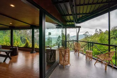 a room with chairs and tables on a balcony at The Berg Ooty Queen of Hills in Ooty