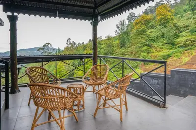 a group of chairs and tables on a balcony at The Berg Ooty Queen of Hills in Ooty