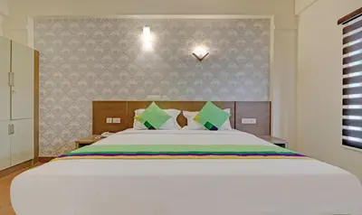 a bedroom with a large white bed in a room at Treebo Golden Terminal Kochi Airport With Swimming Pool in Cochin