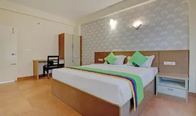 a bedroom with a large bed and a desk at Treebo Golden Terminal Kochi Airport With Swimming Pool in Cochin