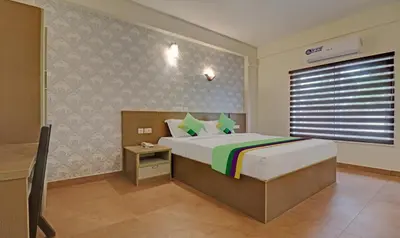 a bedroom with a king sized bed in a room at Treebo Golden Terminal Kochi Airport With Swimming Pool in Cochin