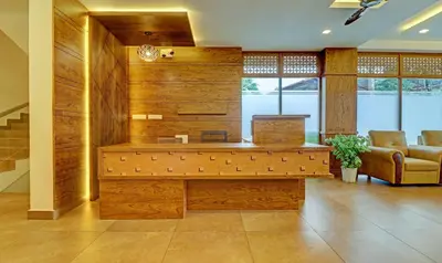 a lobby with a desk and a couch and windows at Treebo Golden Terminal Kochi Airport With Swimming Pool in Cochin