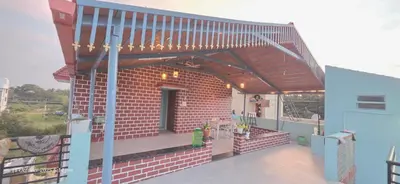a brick house with awning on a balcony at Akshay Sweet Home Stay in Mysore