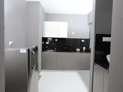 a kitchen with a stainless steel refrigerator in it at Transit Suites by GrandWest in Nedumbassery