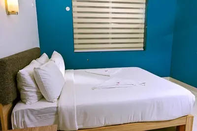 a bed with white sheets and pillows in a room at Transit Suites by GrandWest in Nedumbassery