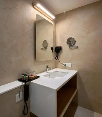 a bathroom with a white sink and a mirror at Lago Leisure Resort & Spa in Cherai Beach