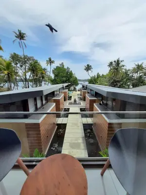 a bird flying over a building with palm trees at Lago Leisure Resort & Spa in Cherai Beach