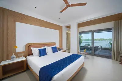 a bedroom with a large bed and a large window at Lago Leisure Resort & Spa in Cherai Beach