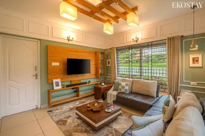 a living room with a couch and a tv at EKO STAY - Woodside Ivy in Ooty