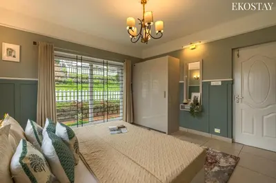 a bedroom with a bed and a large window at EKO STAY - Woodside Ivy in Ooty