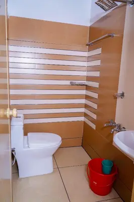 a bathroom with a toilet and a sink at THEKKUMPURAM RESIDENCY in Kondotti