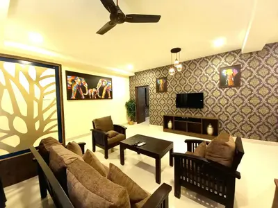 a living room with a couch and a table at Royal Destiny Resort in Malaiyāndipattanam