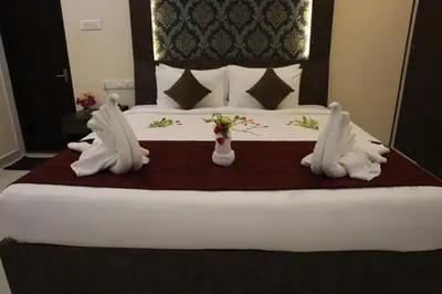 a large bed with two white towels on it at Royal Destiny Resort in Malaiyāndipattanam