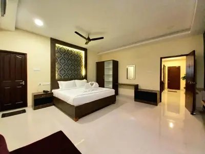 a bedroom with a large white bed in a room at Royal Destiny Resort in Malaiyāndipattanam