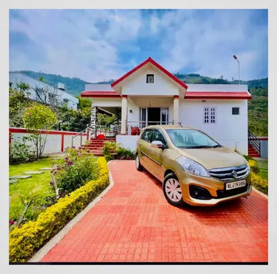 a car parked in front of a house at Kodai Countryside Homestay in Kodaikānāl