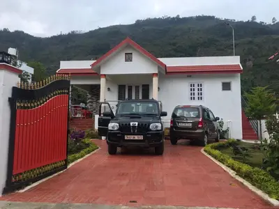 two cars parked in front of a house at Kodai Countryside Homestay in Kodaikānāl