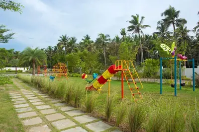 a playground in a park with colorful swings at Blue Serene Backwater Resort in Guruvāyūr