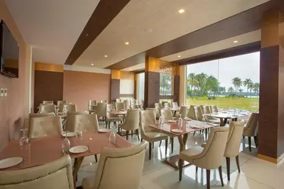 a restaurant with tables and chairs and a large window at Blue Serene Backwater Resort in Guruvāyūr
