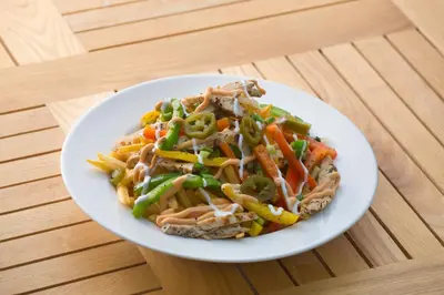 a plate of food with noodles and vegetables on a table at Blue Serene Backwater Resort in Guruvāyūr