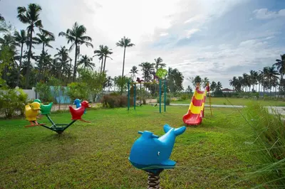 a playground with three play equipment in a park at Blue Serene Backwater Resort in Guruvāyūr