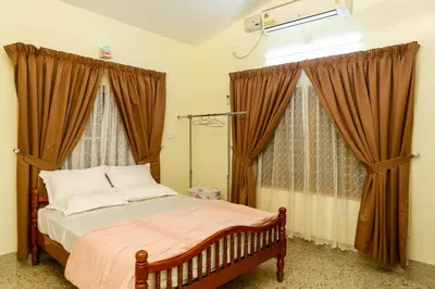 a bedroom with a bed with brown curtains and a bed sidx sidx sidx at Belljem Homes -your own private resort -4 BHK FF in Trichūr