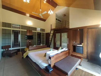 a large bedroom with a large bed and a staircase at Radosri in Coonoor