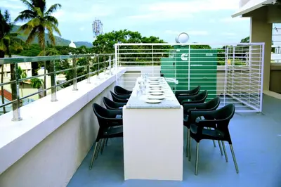 a balcony with a table and chairs on a building at Vismaya Comforts in Mysore