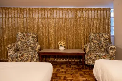 two chairs and a table in a hotel room at Aakash Rooms and Cottages, in Ooty