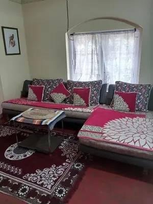 a living room with a couch and a table at Zeus Bungalow in Kotagiri